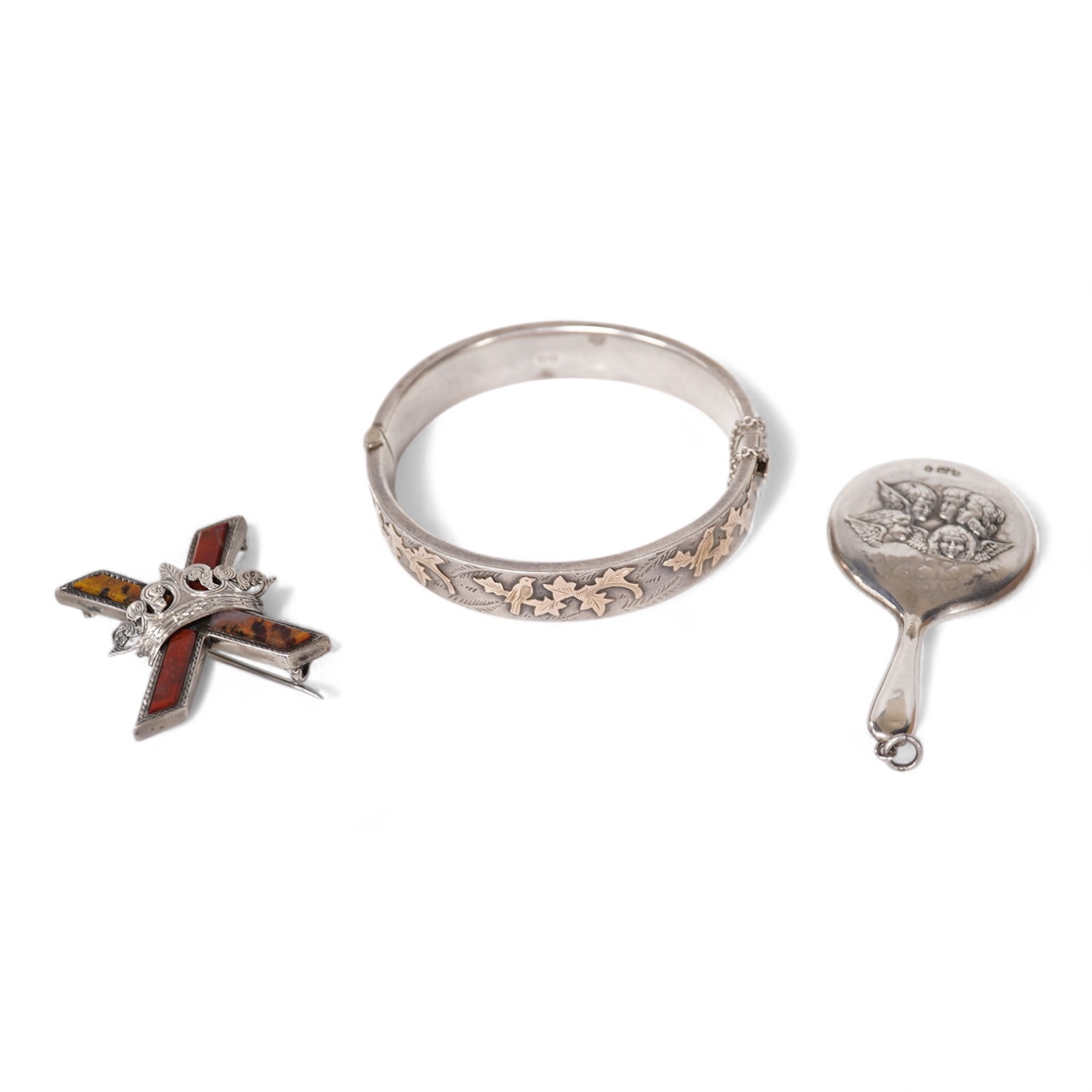 A late Victorian white metal and Scottish hardstone set 'X' brooch with coronet, 34mm, together with a silver hinged bangle and a George V silver mounted handbag mirror, with Reynold's Angels decoration. Condition - poor